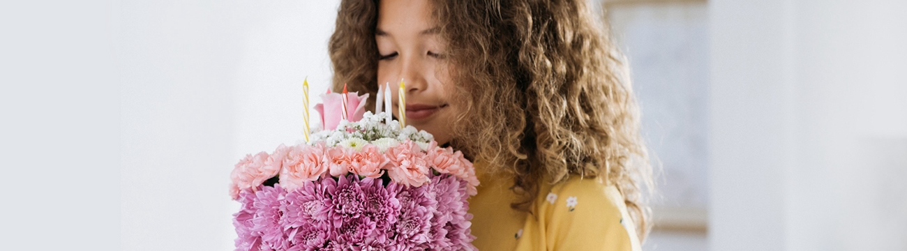 A girl is holding a bunch of fowers.